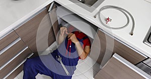 Plumbing services - plumber working in domestic kitchen