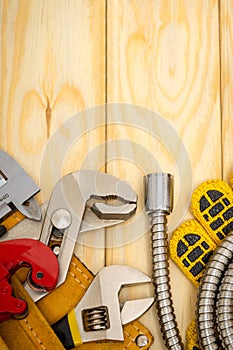 Plumbing tools in the bag and hoses on wooden boards are used to replace or repair