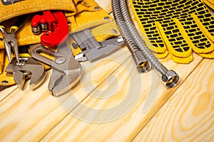 Plumbing tools in the bag and hoses on wooden boards are used to replace or repair