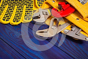 Plumbing tools in the bag and work gloves on blue wooden boards are used to replace or repair