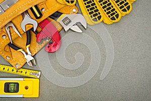 Plumbing tools in the bag and work gloves on gray desktop are used to replace or repair