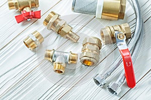 Plumbing tools brass fixtures fittings on white wood board