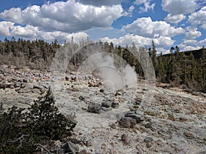 Plume of steam rising from rocks at Yellowstone National Park