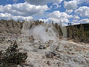 Plume of steam rising from rocks at Yellowstone National Park