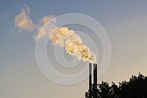 Plume from two factory chimneys on an evening