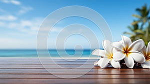 Plumeria flowers on wooden deck with sea and blue sky background