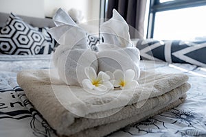 Plumeria and towels on the bed in the luxury hotel room ready for tourist travel