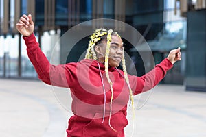 Plump, fat black African American cheerful girl with creative yellow hair, happy young woman dancing and enjoying