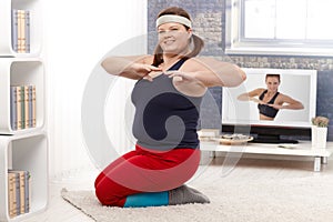 Plump female doing workout at home photo
