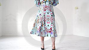 Plump model in a beautiful dress posing in bright studio. Plump woman posing in beautiful outfit.