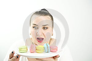 plump plump fat woman holding macaroons on a white plate she bulged her eyes wants to eat them weight loss gain weight