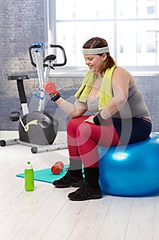 Plump woman exercising with dumbbells photo