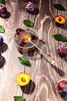 Plums and jam of plum on wood background