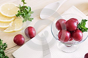 Plums lie in a glass cream bowl on the table, lemon cut into slices, fresh mint leaves, healthy foods, dietary berries and fruits,