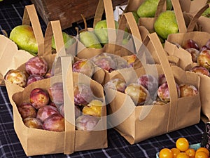 Plums and Pears in Paper Bags at an Outdoor Market