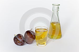 Plums, small glass with tuica and a small bottle 