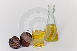 Plums, small glass with tuica and a small bottle 