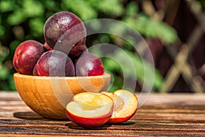 Pluot, mix of plum and apricot in wooden bowl