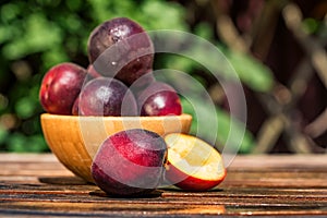 Pluot, mix of plum and apricot in wooden bowl