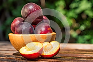 Pluot, mix of plum and apricot in wooden bowl