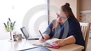 Plus size caucasian business woman multitasking in a bright cafe