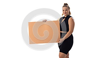 Plus size Caucasian woman in black dress holds blank sign on white background