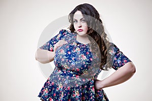 Plus size fashion model in casual clothes, fat woman on beige background, overweight female body