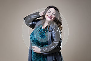 Plus size fashion model in casual clothes, fat woman on beige studio background