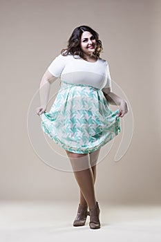 plus size fashion model in casual clothes, fat woman on beige studio background, overweight female body