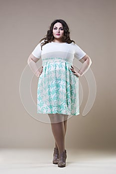 Plus size fashion model in casual clothes, fat woman on beige studio background, overweight female body