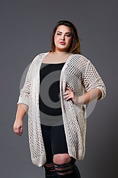 Plus size fashion model in casual clothes, fat woman on gray background