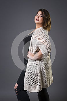 Plus size fashion model in casual clothes, fat woman on gray background, overweight female body