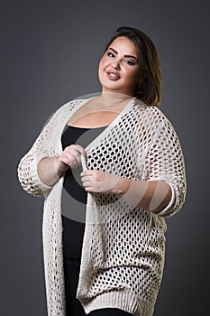 Plus size fashion model in casual clothes, fat woman on gray background, overweight female body