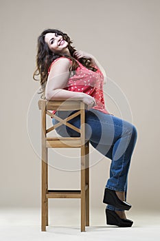 Plus size fashion model in casual clothes, fat woman on studio background, overweight female body