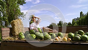 Plus size female model in ethnic costume lying in trailer with watermelons