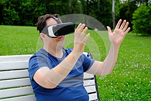 Plus size man wearing virtual reality goggles outdoors