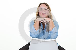 Plus Size Model blonde young woman with long hair blonde sitting back chair hands on chin posing in studio white background