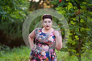 Plus size model in floral dress outdoors, beautiful fat woman with big breasts in nature