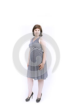 Plus size model in gray medium-length with heels. Isolated on white background