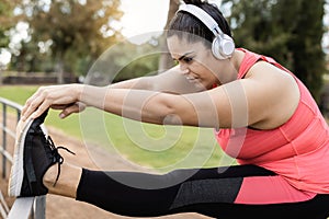 Plus size woman doing stretching day routine outdoor at city park - Focus on face