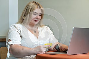 Plus size woman holding Credit Card making Online Shopping or Paying purchases in Internet Store