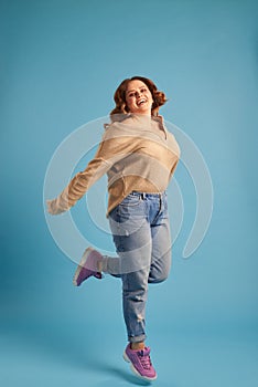 Plus-size woman jumping in excitement at studio