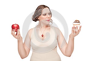 Plus size woman making choice between apple and pastry