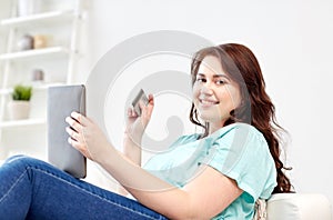 Plus size woman with tablet pc and credit card
