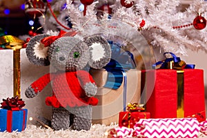 Plush mouse together with gifts under the Christmas tree