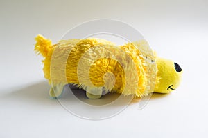 Plush soft children`s toy dog with long yellow hair. Toy reversible on a white background,