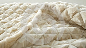 The plush surface of a creamcolored velvet throw with a gentle repeating diamond pattern that invites relaxation photo