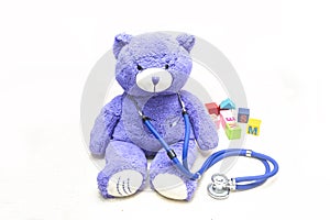 Plush teddy bears, stethoscopes and building blocks on the floor, symbolizing children`s health, medical and health care concept p