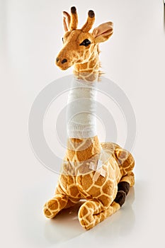 Plush toy giraffe with bandaged neck
