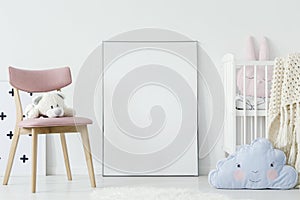 Plush toy on pink chair and blue pillow in child`s room interior